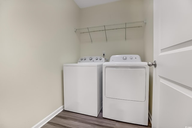 laundry area featuring wood-type flooring and separate washer and dryer