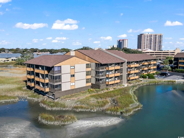 view of building exterior featuring central AC unit and a water view