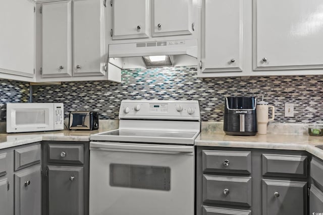 kitchen featuring ventilation hood, gray cabinets, white appliances, and tasteful backsplash