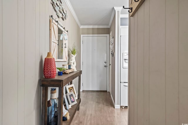 hallway featuring light hardwood / wood-style flooring, crown molding, and wood walls