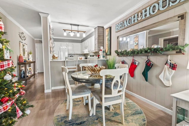 dining space featuring crown molding and hardwood / wood-style flooring