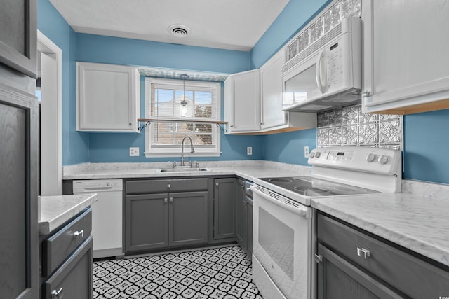 kitchen featuring gray cabinetry, white appliances, sink, pendant lighting, and white cabinets