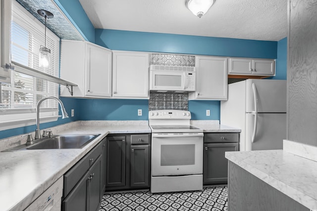 kitchen with white cabinets, white appliances, decorative light fixtures, and sink