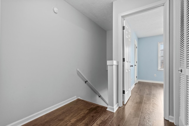 hall featuring dark hardwood / wood-style floors and a textured ceiling