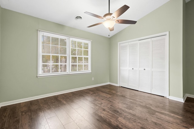 unfurnished bedroom featuring ceiling fan, a closet, dark wood-type flooring, and vaulted ceiling