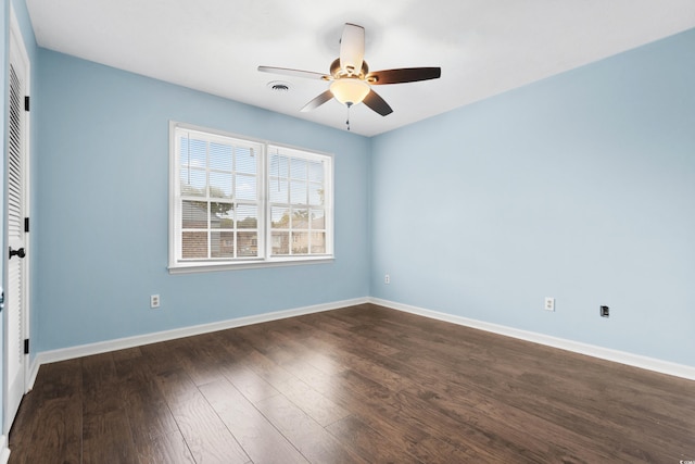 unfurnished room with ceiling fan and dark wood-type flooring