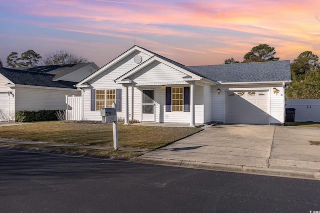 single story home featuring a garage and a yard