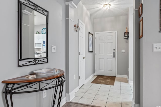 foyer featuring light tile patterned floors and a textured ceiling