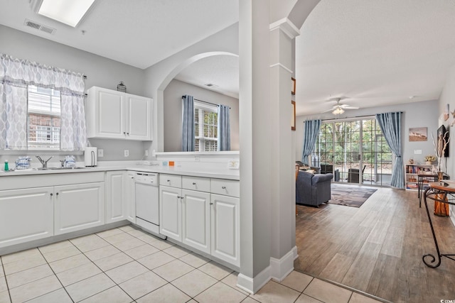 kitchen featuring dishwasher, white cabinetry, and a wealth of natural light