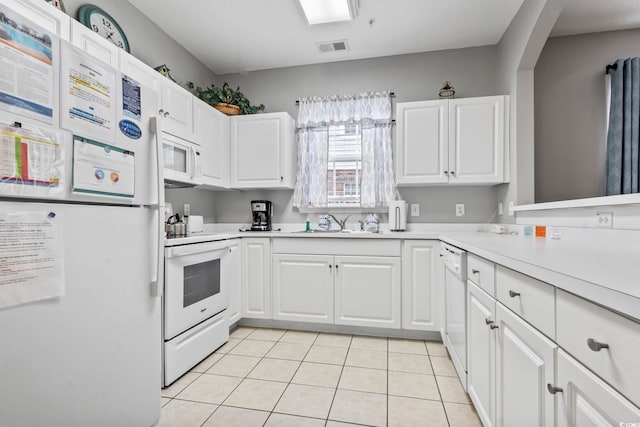 kitchen featuring white cabinetry, light tile patterned floors, and white appliances