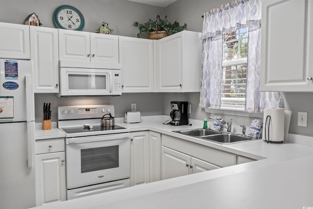 kitchen featuring white appliances, white cabinetry, and sink