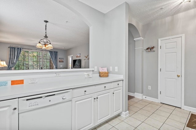 kitchen with white dishwasher, white cabinets, hanging light fixtures, light tile patterned floors, and a textured ceiling