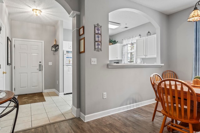 entryway with light hardwood / wood-style floors and a textured ceiling