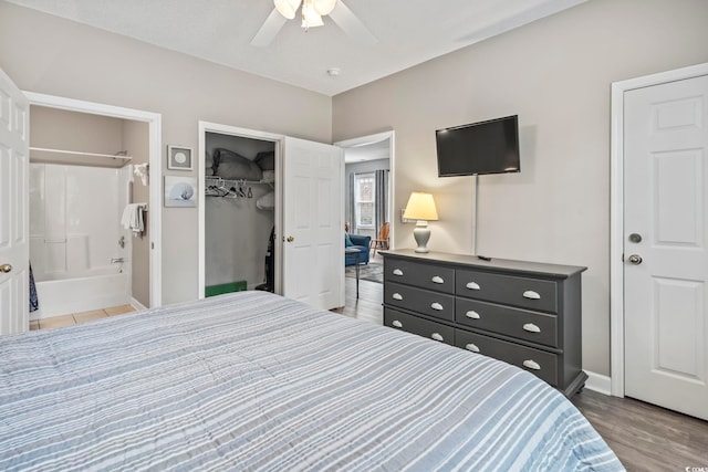 bedroom with ceiling fan, a spacious closet, ensuite bathroom, light hardwood / wood-style floors, and a closet