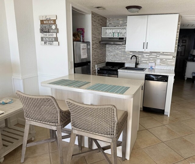 kitchen featuring white cabinets, stainless steel appliances, sink, and kitchen peninsula