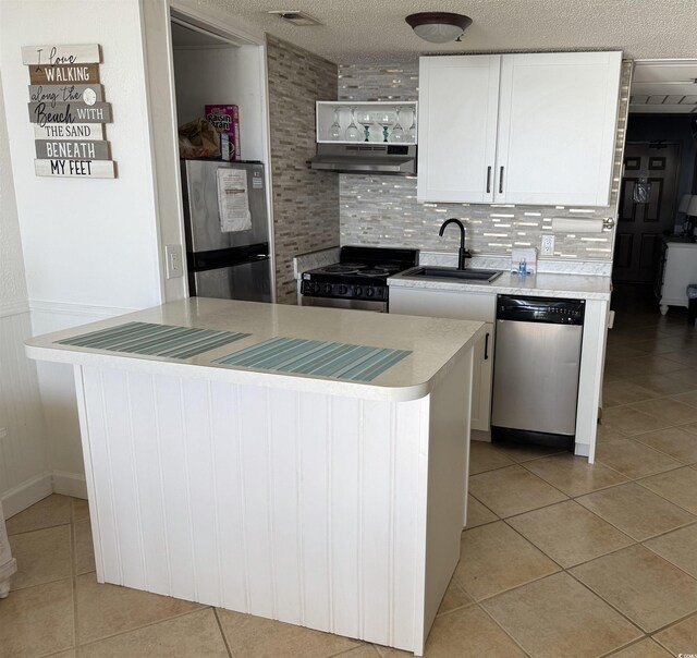 kitchen featuring stainless steel appliances, sink, white cabinets, a textured ceiling, and tasteful backsplash