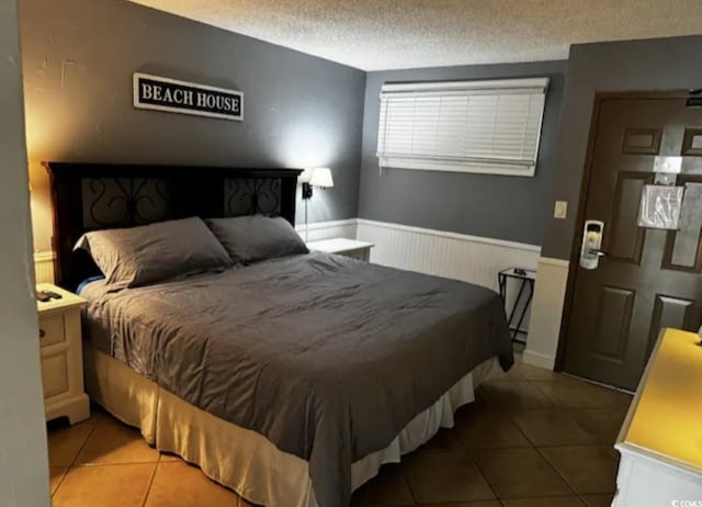 tiled bedroom with a textured ceiling