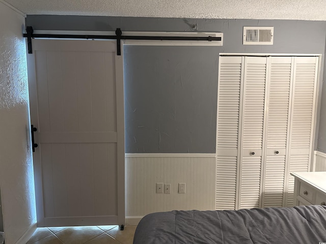 bedroom featuring a textured ceiling, a closet, and a barn door