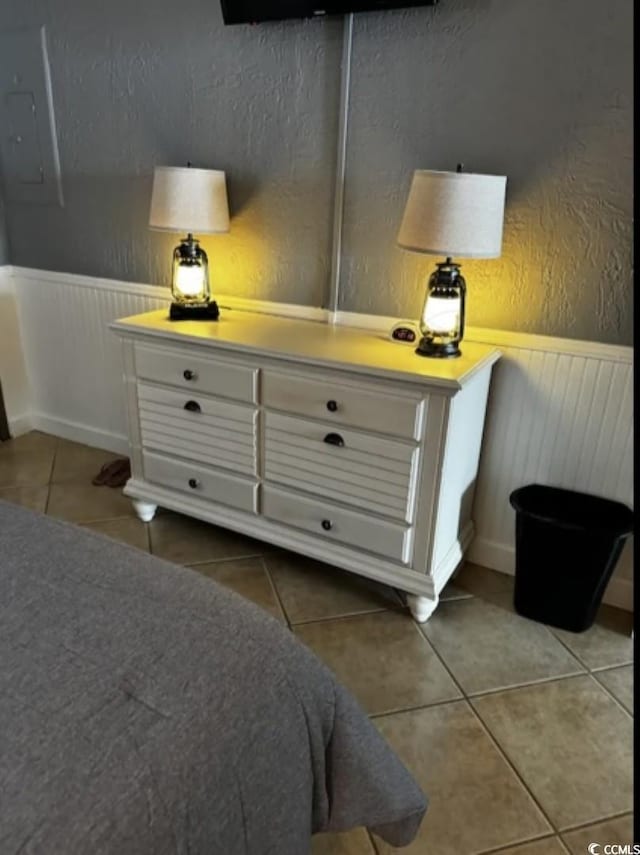 bedroom featuring electric panel and tile patterned flooring