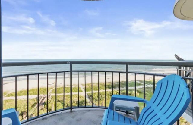 balcony featuring a beach view and a water view