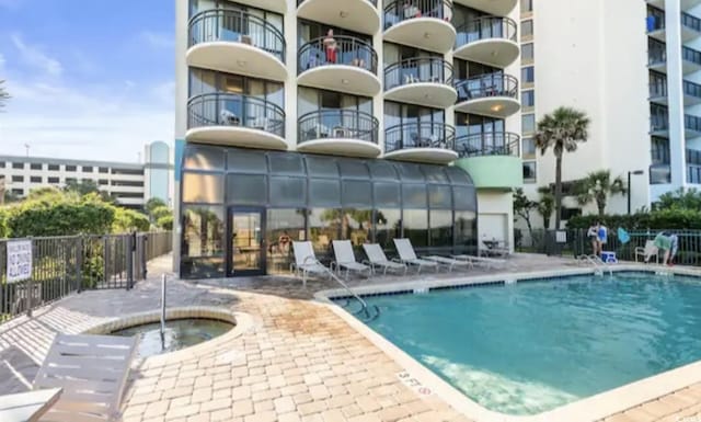 view of pool featuring a hot tub and a patio