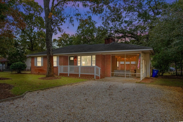 ranch-style house with covered porch and a yard