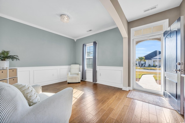 interior space with hardwood / wood-style floors and ornamental molding