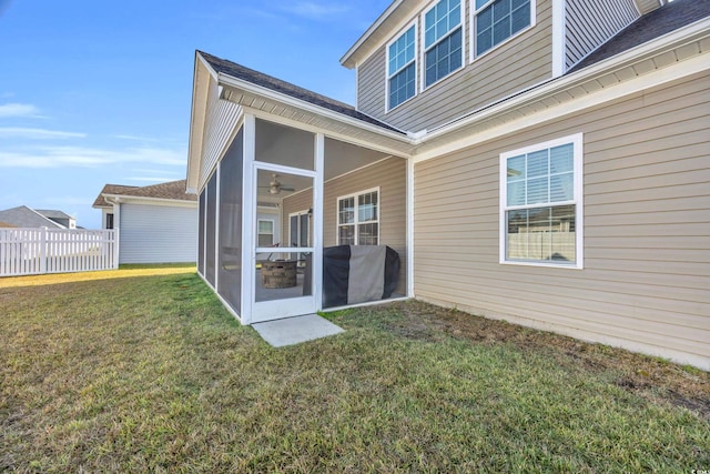 back of property featuring a sunroom and a lawn