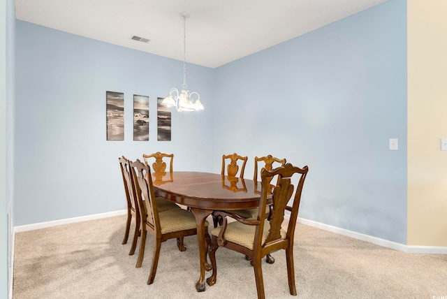 dining space with light carpet, a notable chandelier, visible vents, and baseboards