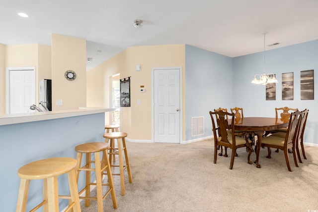 dining area with light colored carpet, visible vents, baseboards, and an inviting chandelier