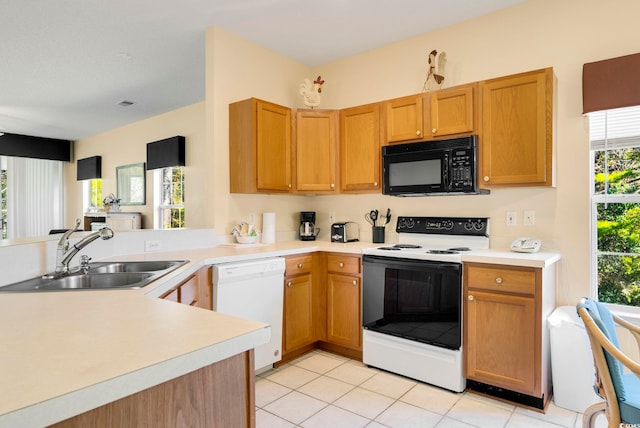 kitchen featuring black microwave, electric range oven, white dishwasher, and light countertops