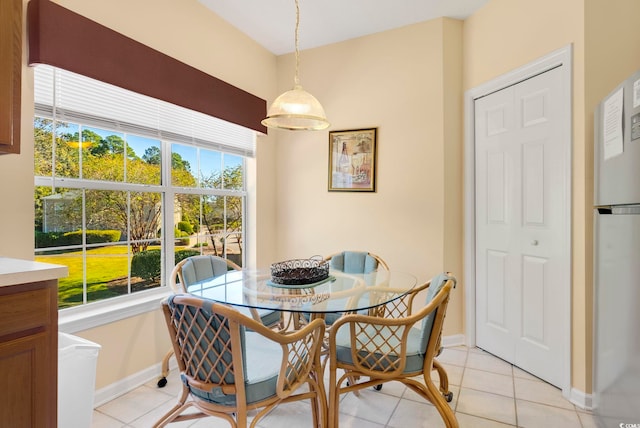 dining room featuring plenty of natural light, light tile patterned flooring, and baseboards