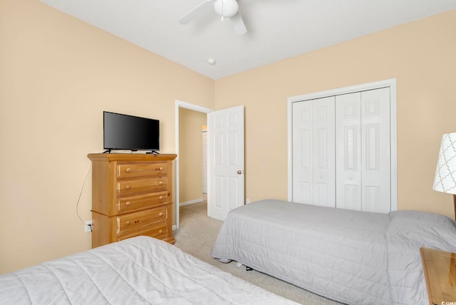 bedroom with light carpet, ceiling fan, and a closet