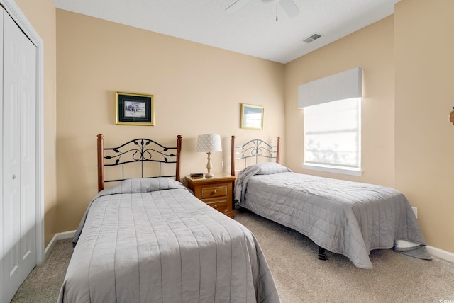 bedroom featuring baseboards, visible vents, a ceiling fan, carpet flooring, and a closet