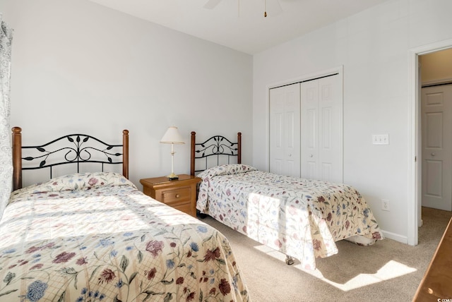 carpeted bedroom with a ceiling fan, a closet, and baseboards