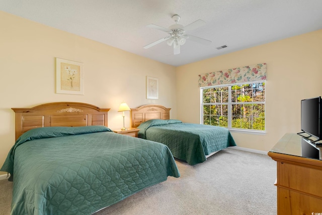 carpeted bedroom with baseboards, visible vents, and a ceiling fan