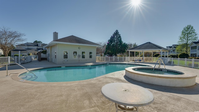 pool featuring a patio area, a hot tub, fence, and a gazebo