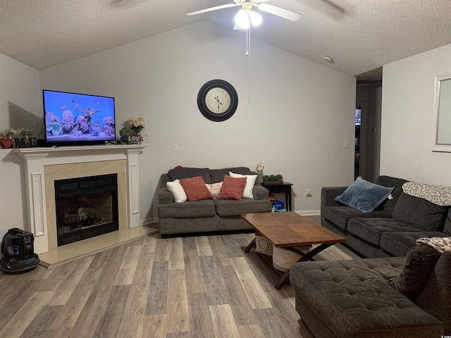 living room featuring hardwood / wood-style floors, a textured ceiling, vaulted ceiling, and ceiling fan