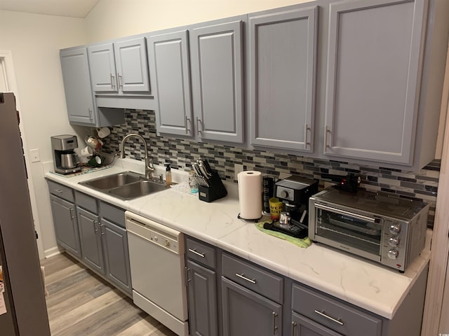 kitchen featuring gray cabinets, dishwasher, and sink