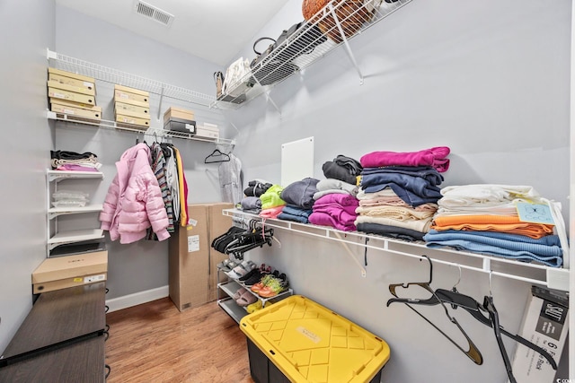 walk in closet with visible vents and wood finished floors