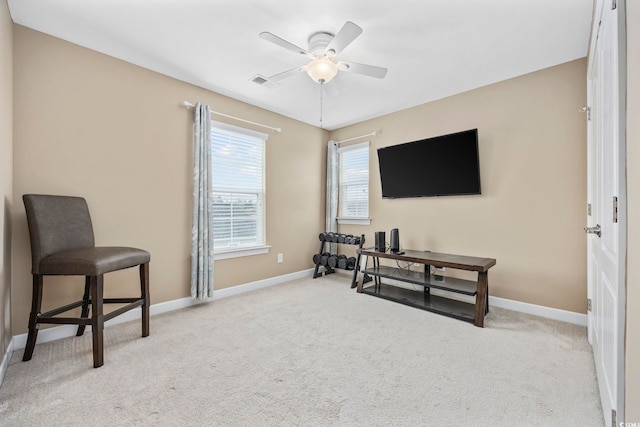 sitting room featuring baseboards, visible vents, a ceiling fan, and light colored carpet