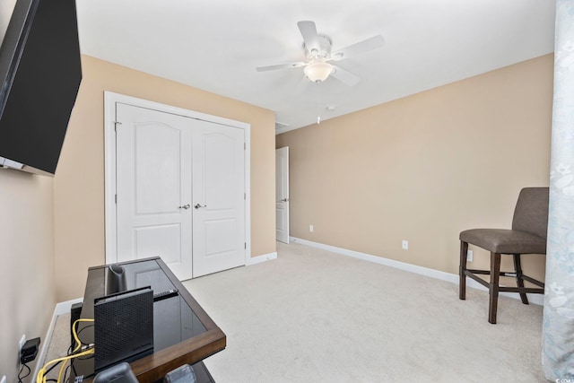 home office with light carpet, ceiling fan, and baseboards