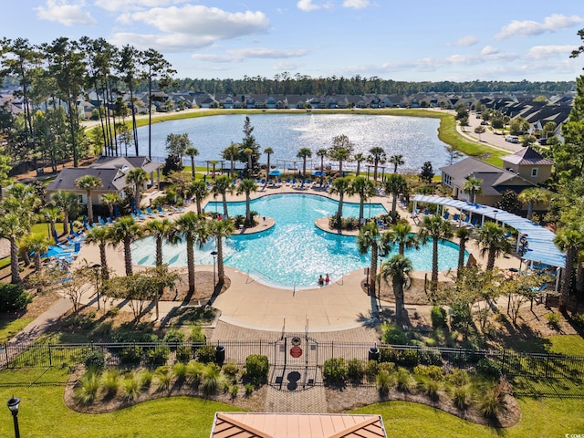 pool featuring a water view, a residential view, fence, and a patio