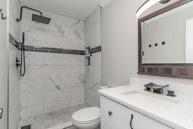 bathroom with vanity, toilet, and a tile shower