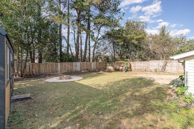 view of yard with a playground and an outdoor fire pit