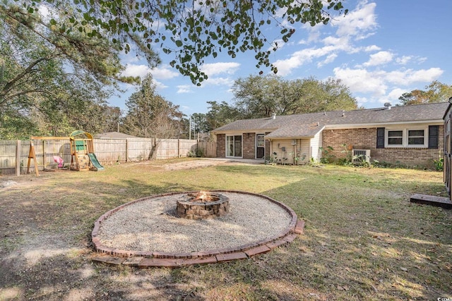 view of yard featuring a playground and an outdoor fire pit