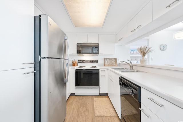 kitchen featuring sink, light hardwood / wood-style floors, white cabinetry, and black appliances