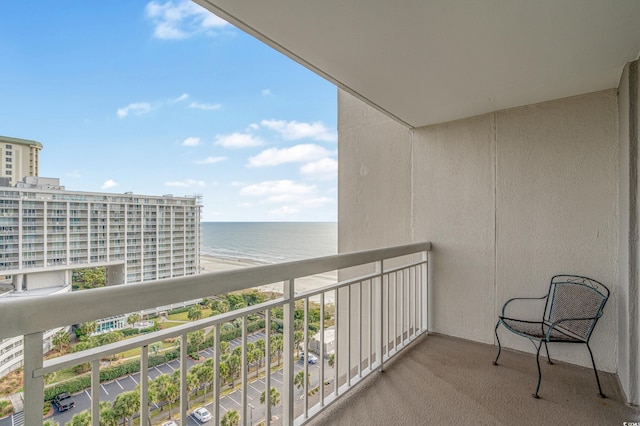 balcony with a water view and a view of the beach