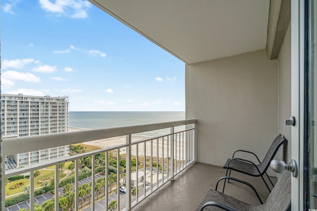 balcony with a water view and a view of the beach