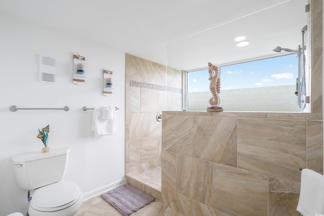 bathroom featuring tiled shower, tile patterned flooring, and toilet